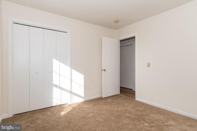 unfurnished bedroom with light carpet and a closet