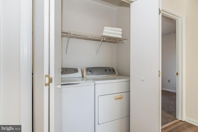 laundry room with independent washer and dryer and wood-type flooring