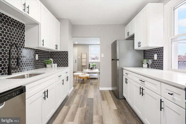 kitchen featuring white cabinetry, appliances with stainless steel finishes, and a wealth of natural light