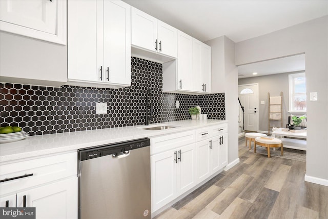 kitchen featuring stainless steel dishwasher, white cabinets, and sink