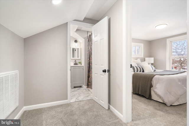 bedroom featuring light colored carpet, sink, and lofted ceiling