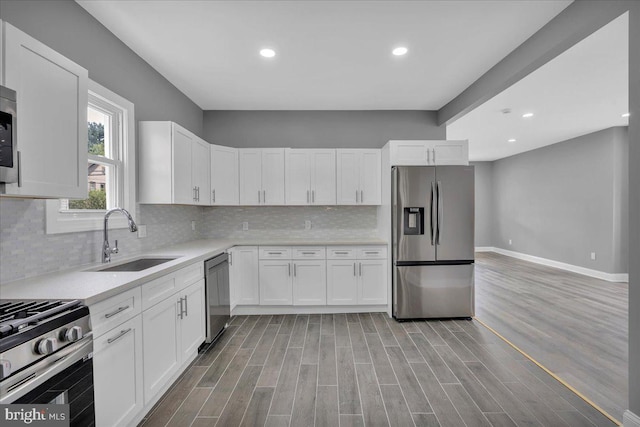 kitchen with light hardwood / wood-style flooring, sink, stainless steel appliances, and white cabinetry