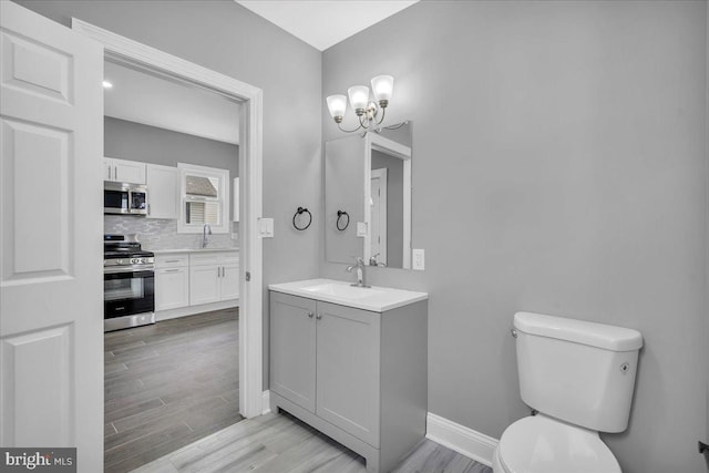 bathroom featuring hardwood / wood-style floors, vanity, tasteful backsplash, toilet, and a chandelier