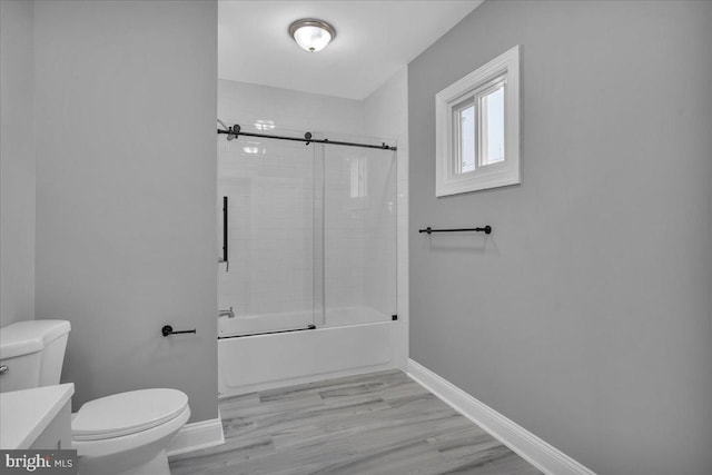 full bathroom featuring toilet, enclosed tub / shower combo, wood-type flooring, and vanity