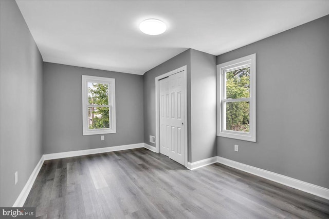 unfurnished bedroom featuring a closet and hardwood / wood-style floors