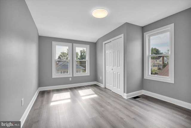 unfurnished bedroom with a closet and light wood-type flooring