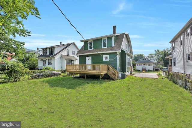 rear view of property with central AC, a yard, and a wooden deck