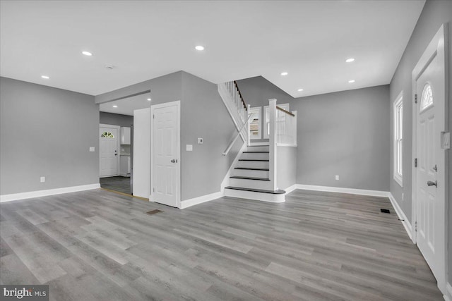 unfurnished living room with light wood-type flooring and a wealth of natural light