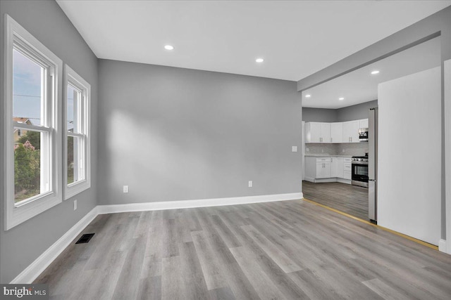 unfurnished living room with a wealth of natural light and light hardwood / wood-style floors