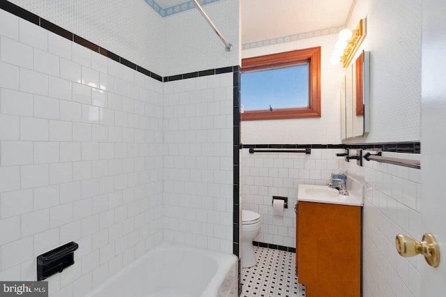 full bathroom with shower / bathing tub combination, tile walls, tile patterned flooring, vanity, and toilet