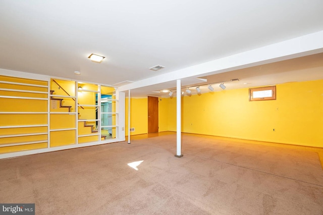 basement with carpet and track lighting