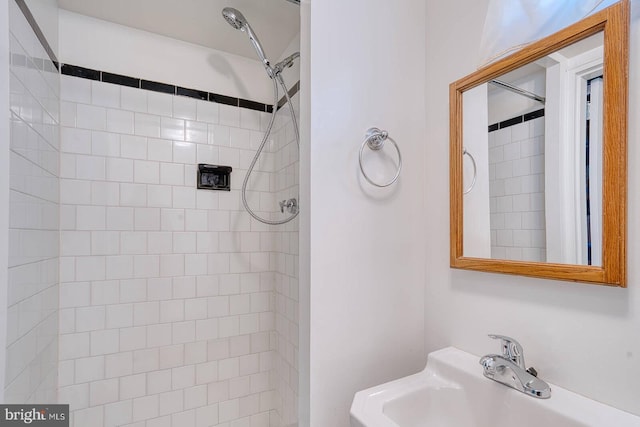 bathroom featuring sink and a tile shower