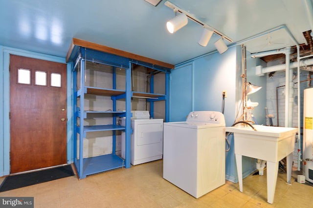 washroom with water heater, washing machine and dryer, and track lighting