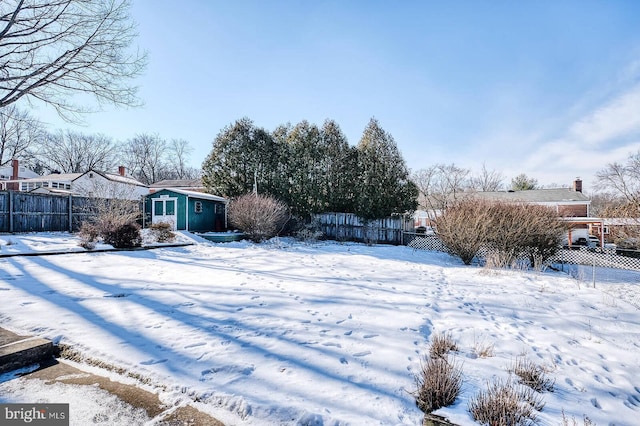 yard covered in snow featuring an outbuilding