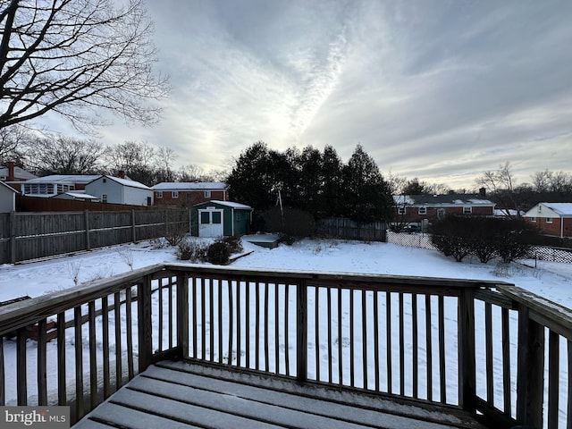 snow covered deck featuring a storage unit