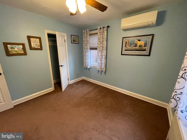 unfurnished bedroom with a wall unit AC, ceiling fan, and dark colored carpet