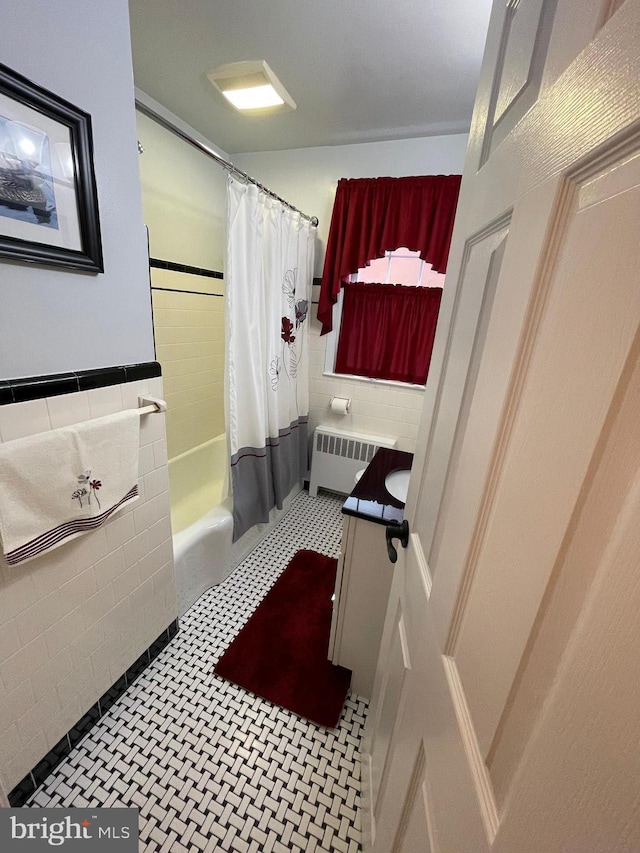 bathroom with vanity, radiator, shower / tub combo, and tile walls