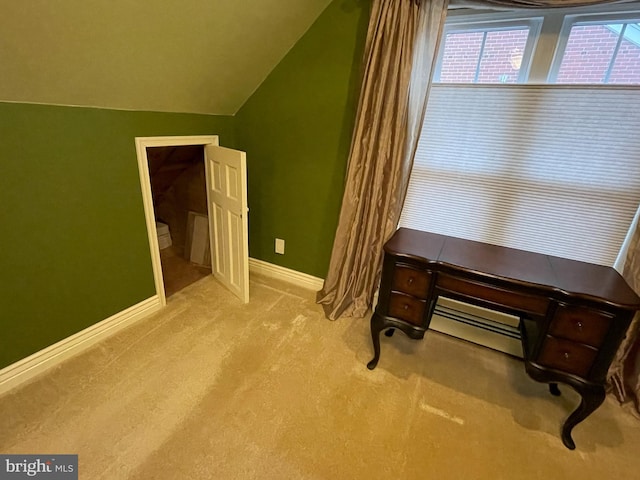 home office with a baseboard radiator, vaulted ceiling, and light carpet