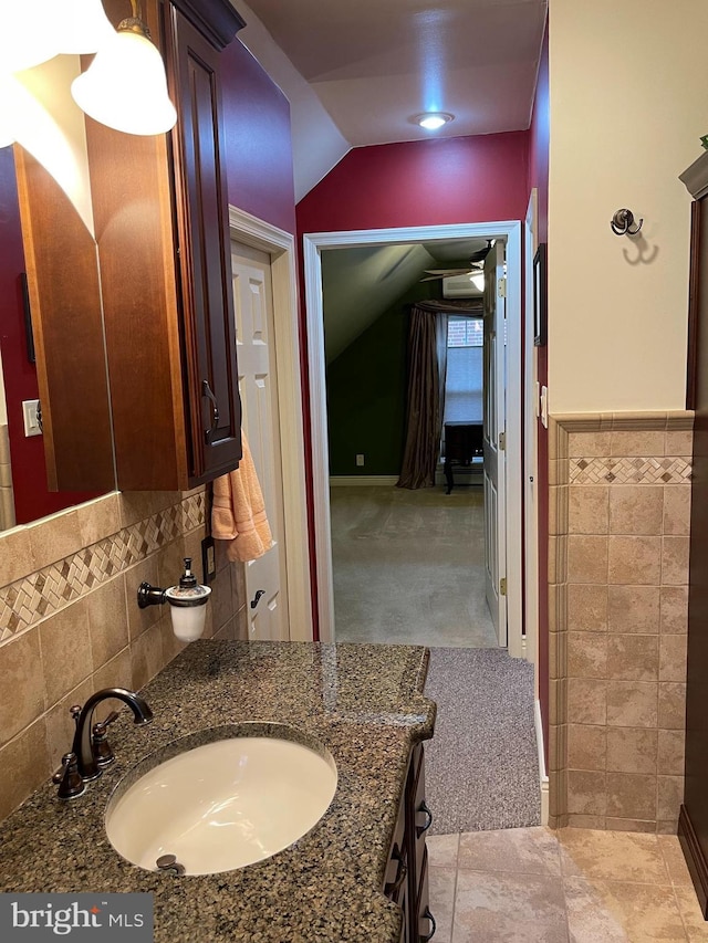 bathroom featuring vanity and tile walls