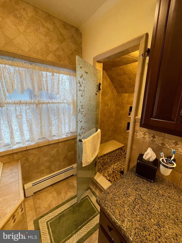 bathroom featuring a healthy amount of sunlight, lofted ceiling, and a baseboard heating unit