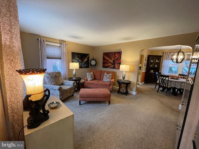 carpeted living room featuring a notable chandelier and a wealth of natural light