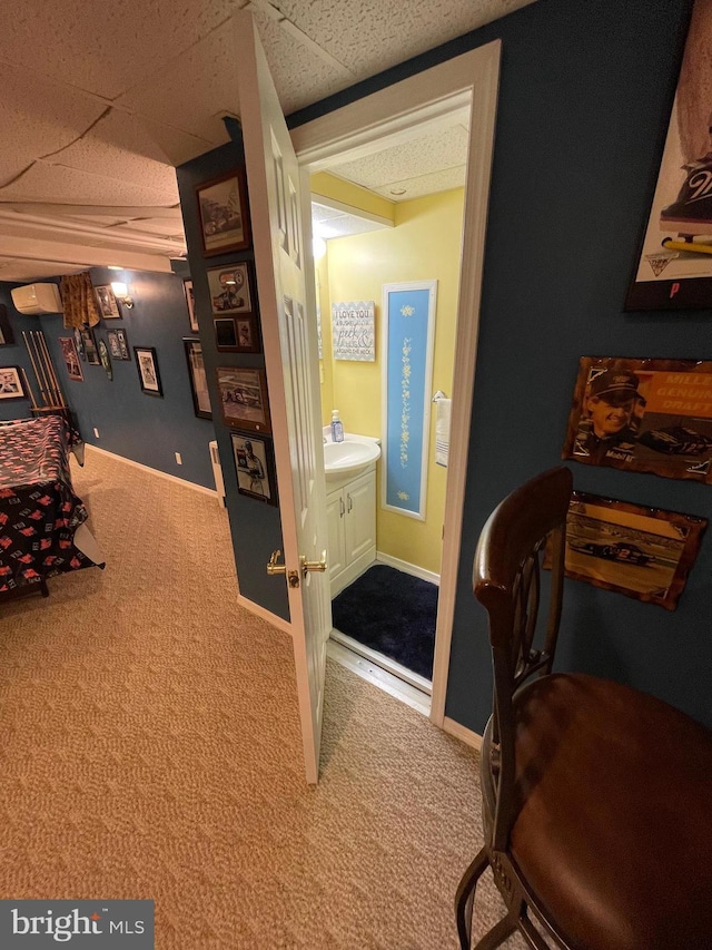 bedroom featuring carpet floors, sink, connected bathroom, and a paneled ceiling