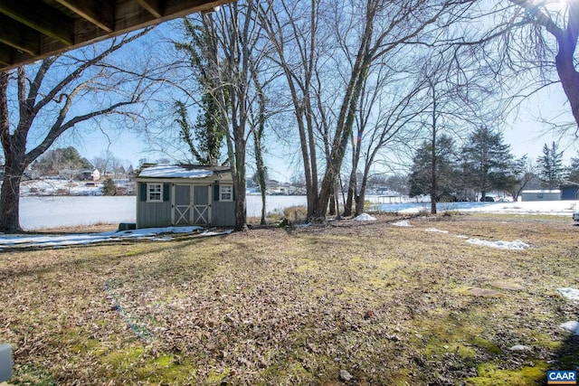 view of yard featuring a storage shed and a water view