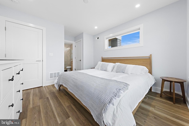 bedroom featuring dark wood-type flooring and ensuite bathroom