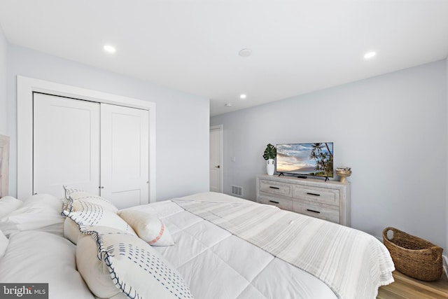 bedroom with light hardwood / wood-style floors and a closet