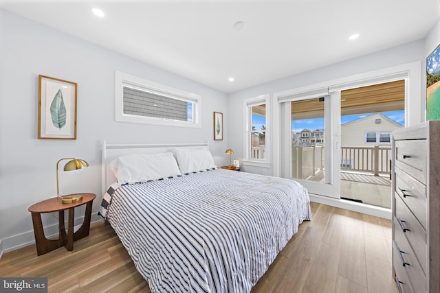 bedroom with hardwood / wood-style floors and access to outside