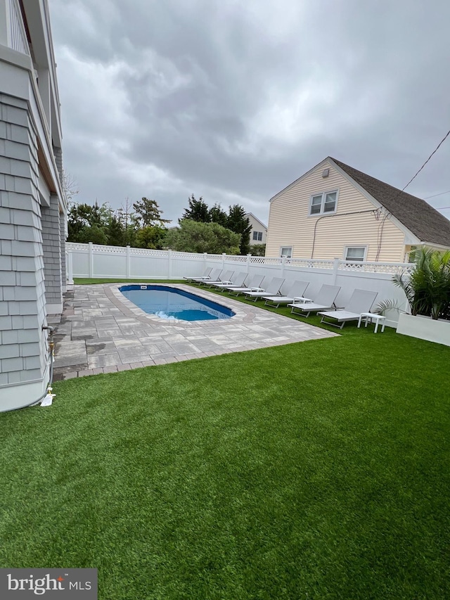 view of swimming pool with a patio area and a lawn