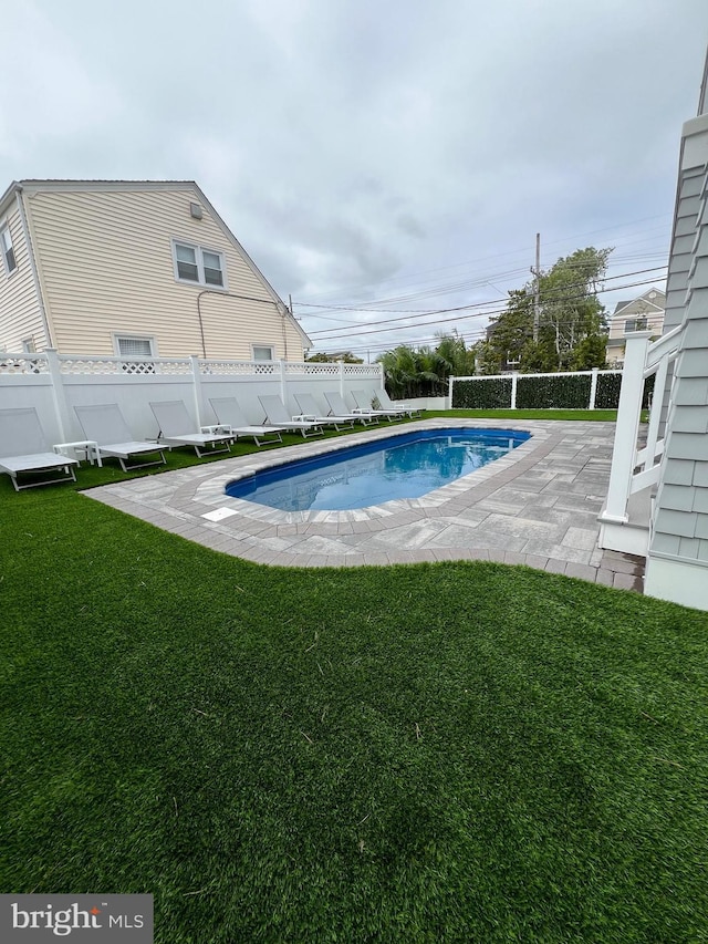 view of swimming pool featuring a lawn