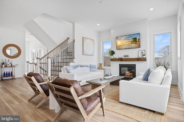 living room with a large fireplace and light hardwood / wood-style floors