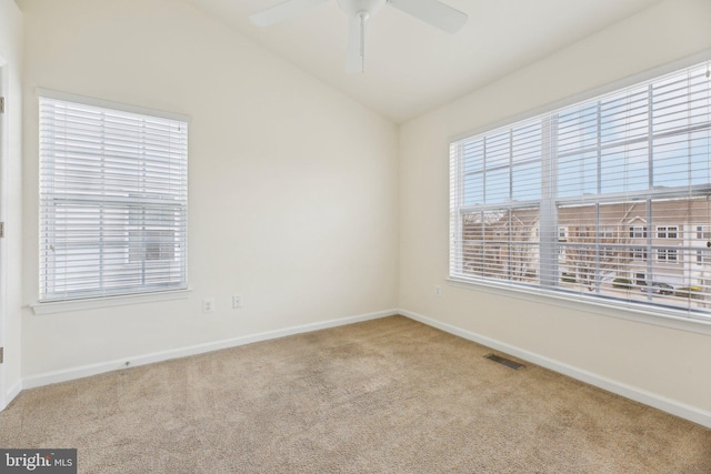 spare room with light carpet, a wealth of natural light, lofted ceiling, and ceiling fan