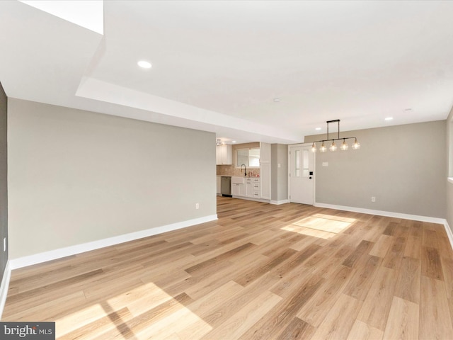 unfurnished living room featuring light hardwood / wood-style floors and sink