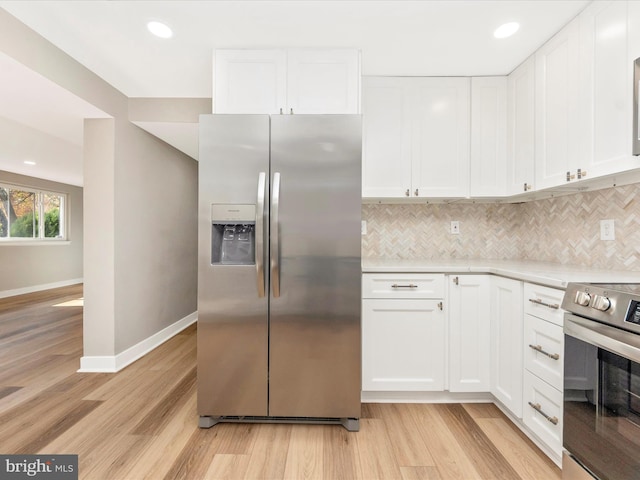 kitchen with white cabinets, light hardwood / wood-style flooring, and stainless steel appliances