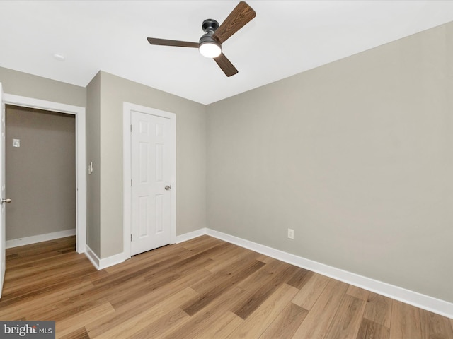 unfurnished bedroom featuring light wood-type flooring, ceiling fan, and a closet