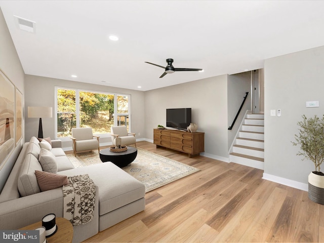 living room featuring wood-type flooring and ceiling fan