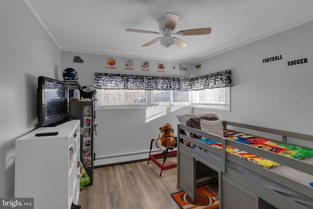 bedroom featuring light hardwood / wood-style floors, a baseboard heating unit, ornamental molding, and ceiling fan