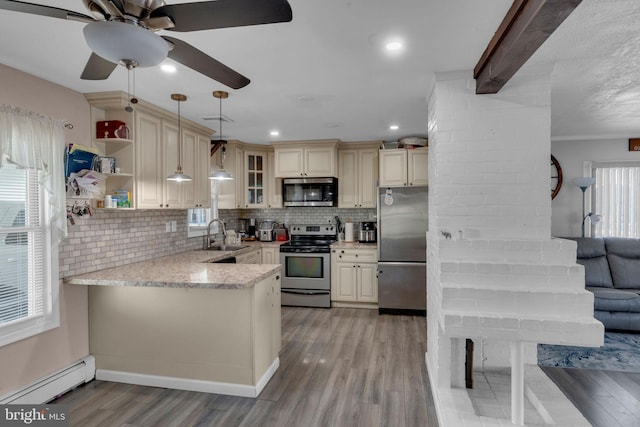 kitchen with kitchen peninsula, appliances with stainless steel finishes, backsplash, decorative light fixtures, and sink