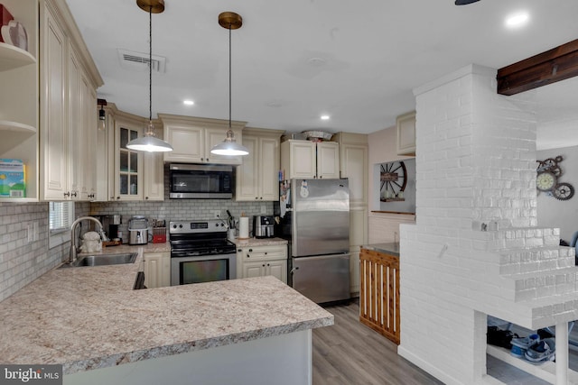 kitchen with stainless steel appliances, tasteful backsplash, decorative light fixtures, light wood-type flooring, and sink