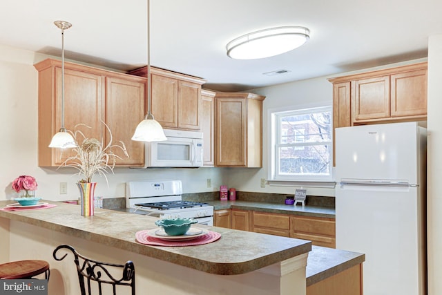 kitchen featuring a kitchen breakfast bar, decorative light fixtures, kitchen peninsula, and white appliances