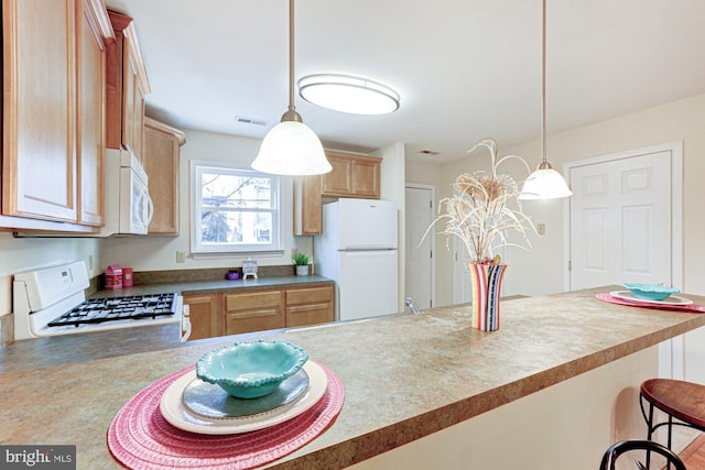 kitchen with a kitchen breakfast bar, decorative light fixtures, light brown cabinetry, and white appliances