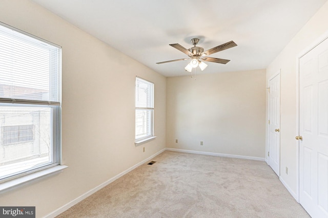 spare room featuring ceiling fan and light colored carpet