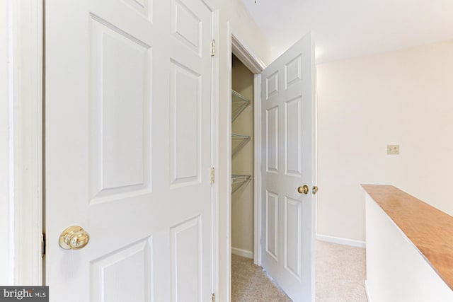 hall with light colored carpet