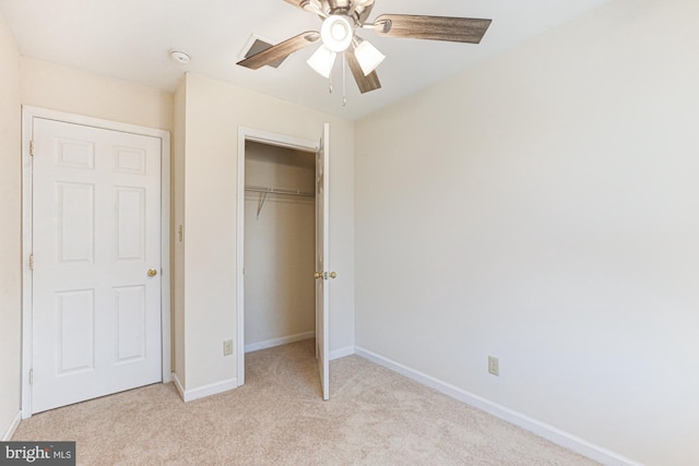 unfurnished bedroom with ceiling fan, light colored carpet, and a closet