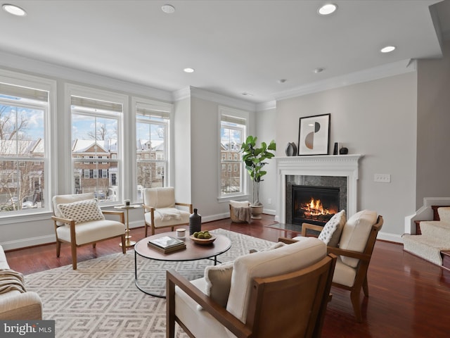 living room featuring a wealth of natural light, ornamental molding, and light wood-type flooring