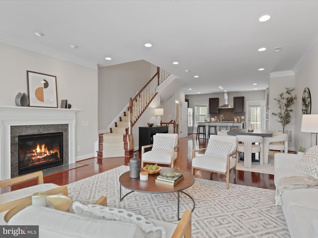 living room with light wood-type flooring and ornamental molding