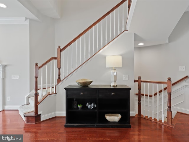 stairs featuring ornamental molding and wood-type flooring