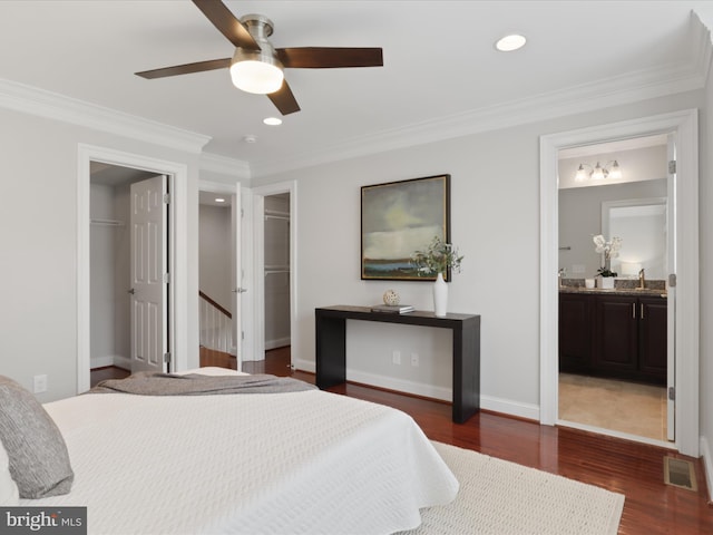 bedroom with ceiling fan, ensuite bathroom, a spacious closet, and dark hardwood / wood-style floors